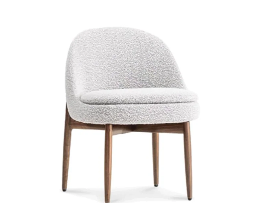 Rounded cream bucket dining chair with warm tapered wood legs