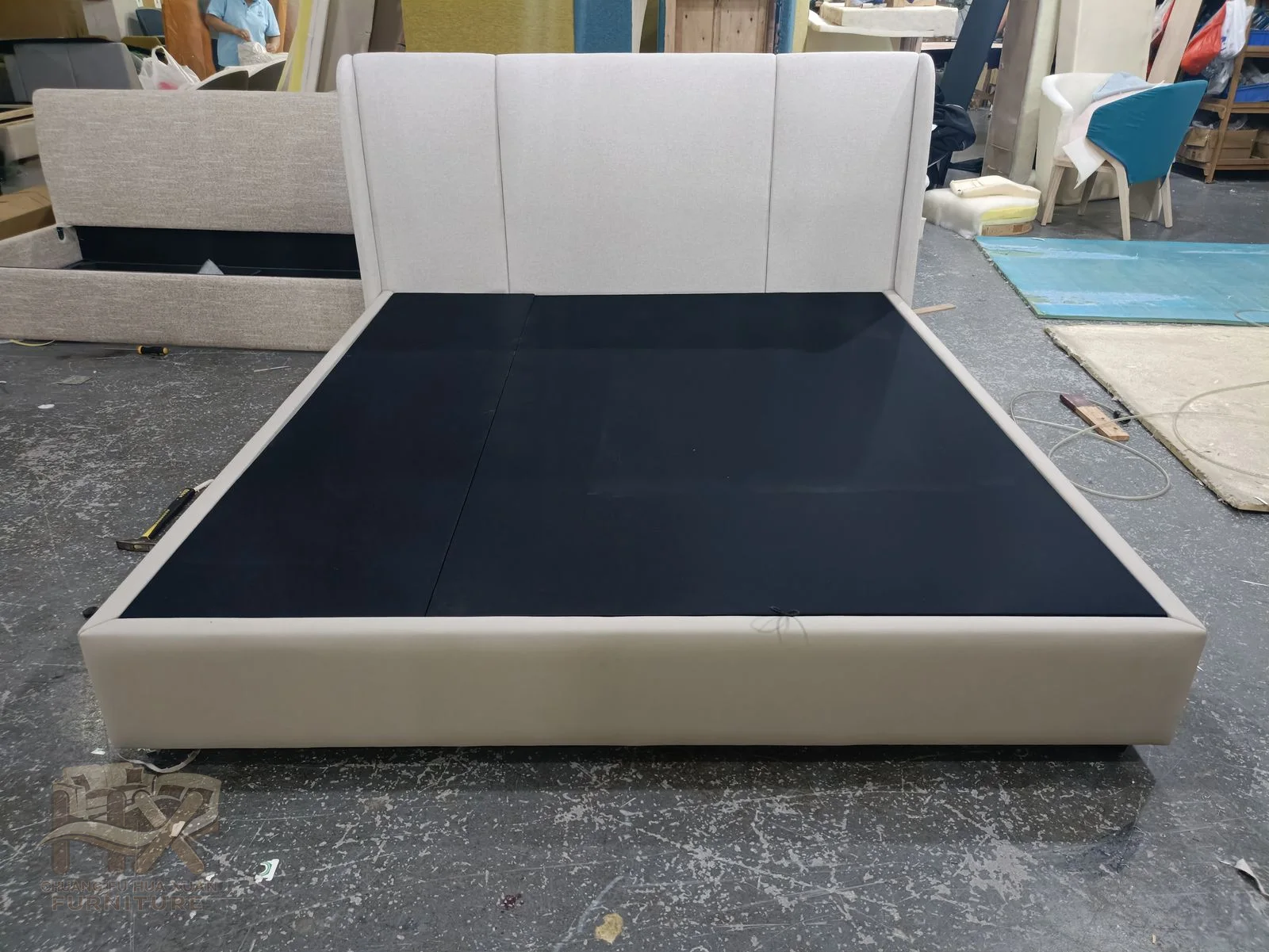 A broad white headboard uses a few large vertical panels above a matching low base.