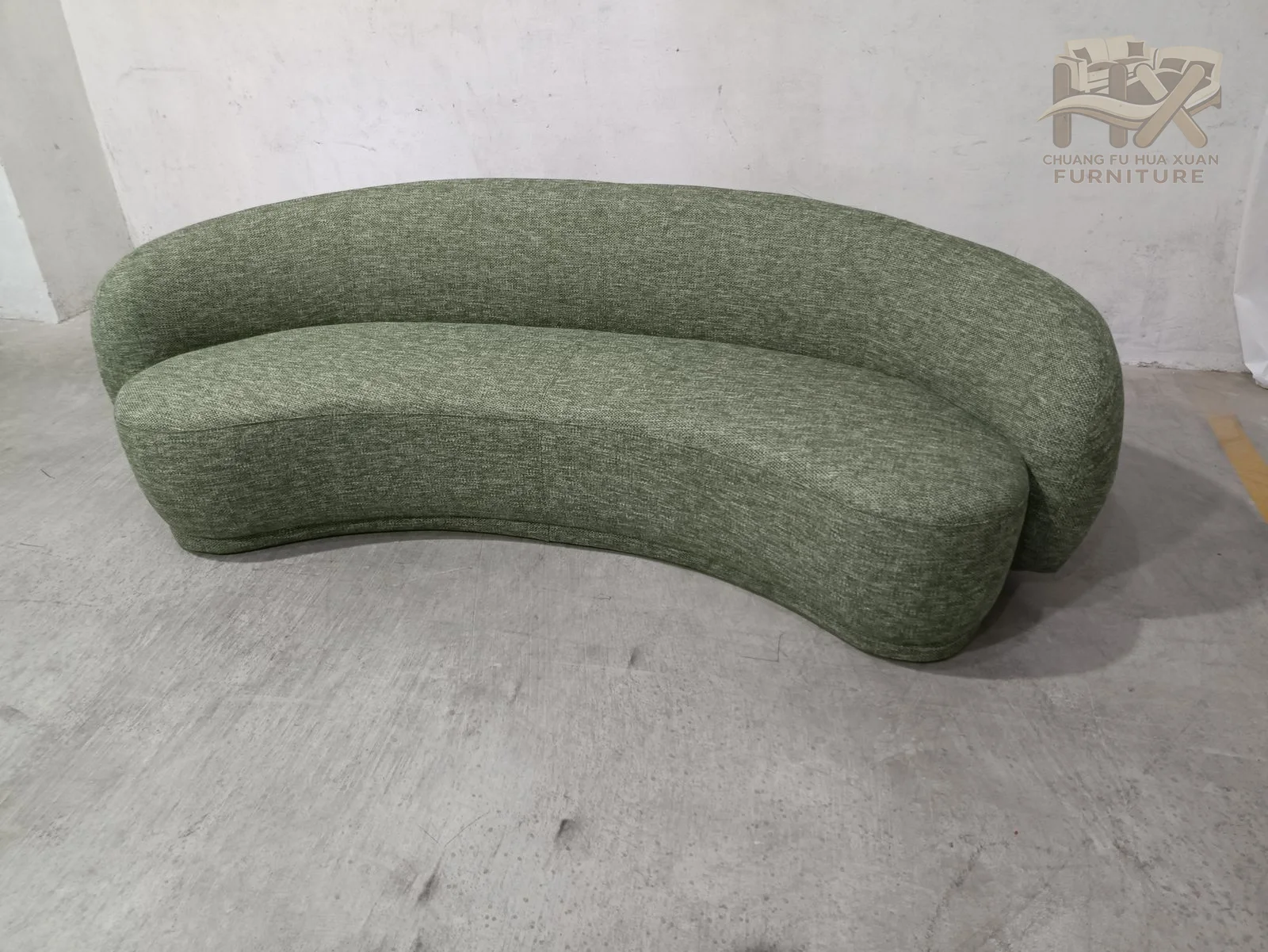 A long, low bench sweeps through a curved plan, with a raised upholstered back following the outer edge and no exposed legs.