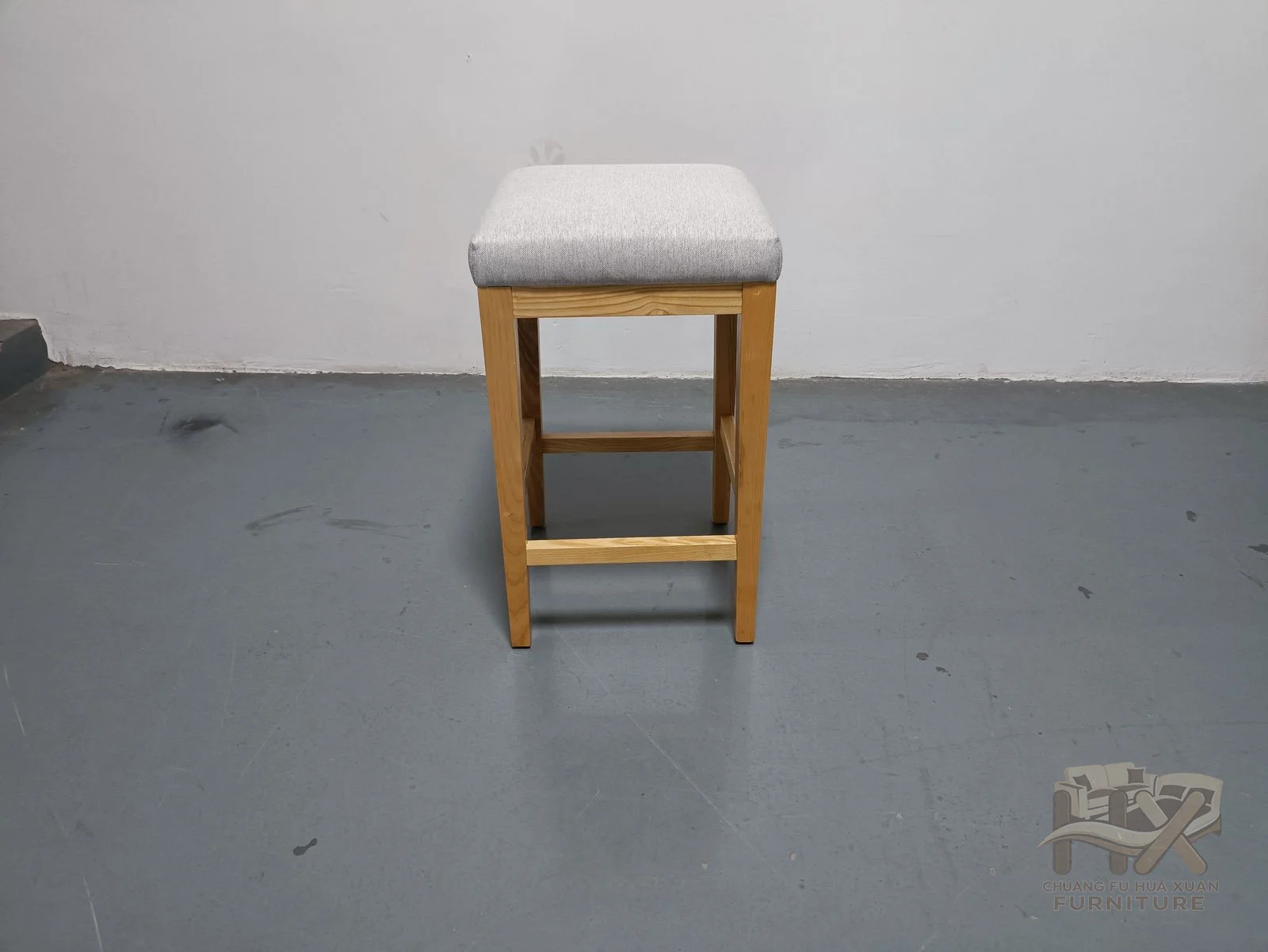 A narrow padded counter seat rises on tall slim legs with a low foot rail.