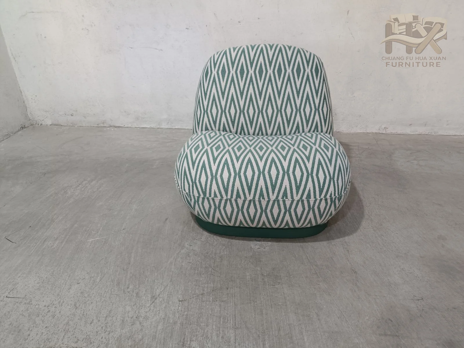 A low, rounded seat rises into a softly curved back, with a fine blue and white patterned cover running continuously around the shell.