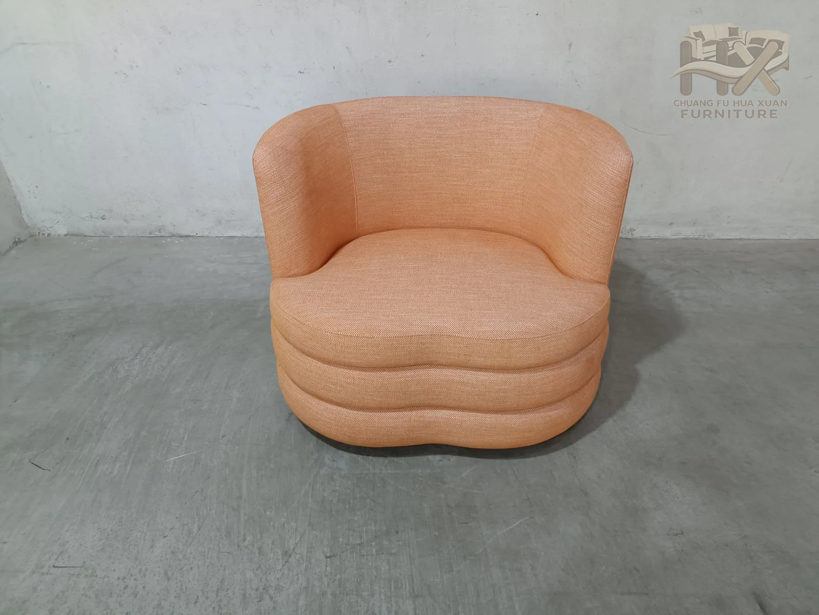 Three horizontal upholstered bands define the low base beneath a peach-coloured wraparound back and a deeply rounded seat.