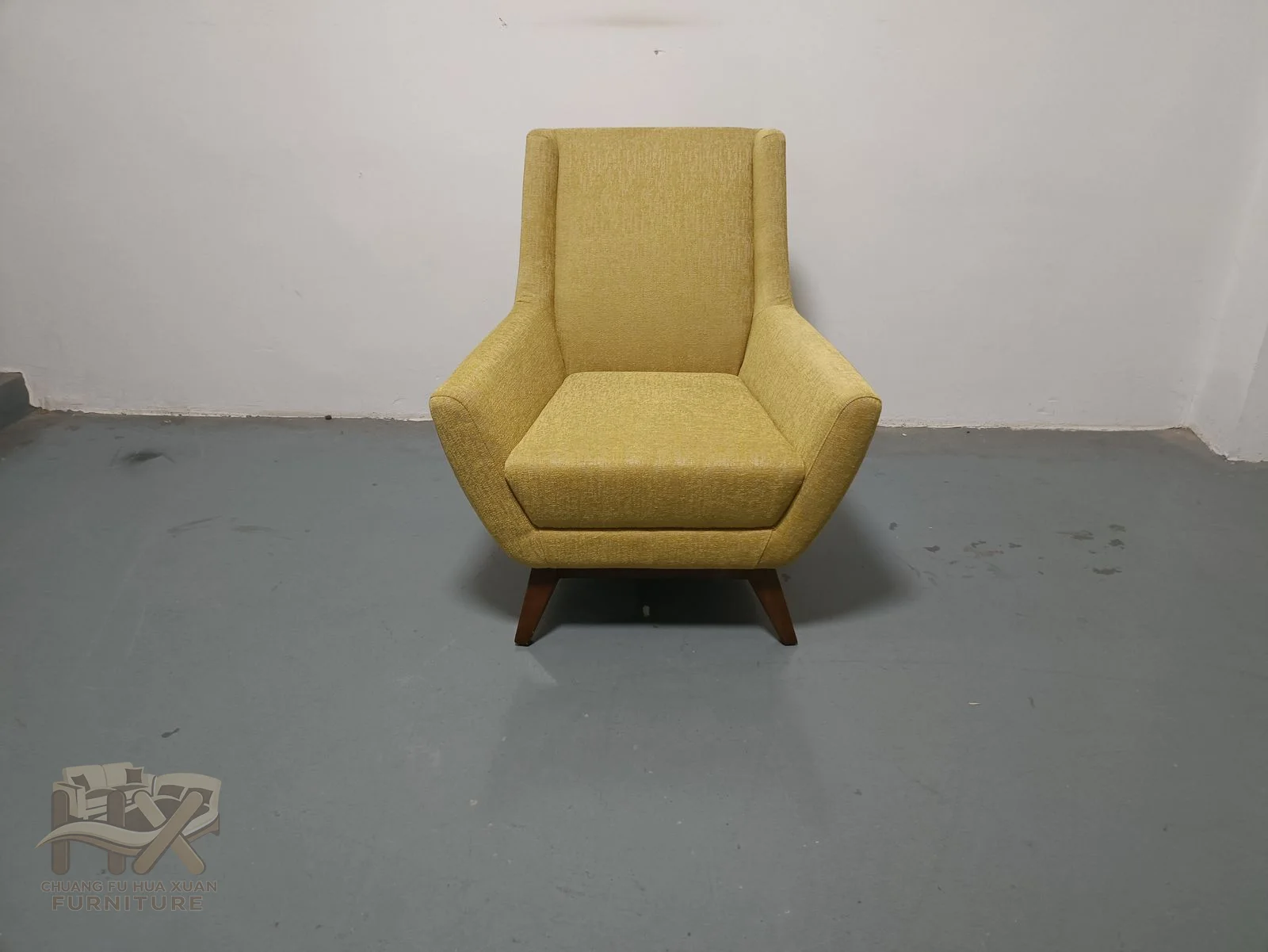 A slim seat rises into a tall tapered back, while angled upholstered arms and short dark legs sharpen the chair's profile.