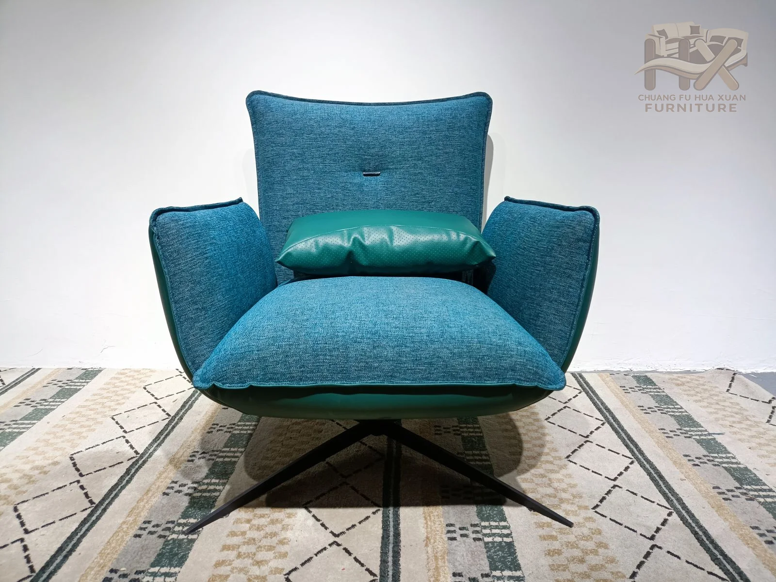 The teal chair opens into a wide flared top edge above a narrower cushioned seat and short exposed legs.