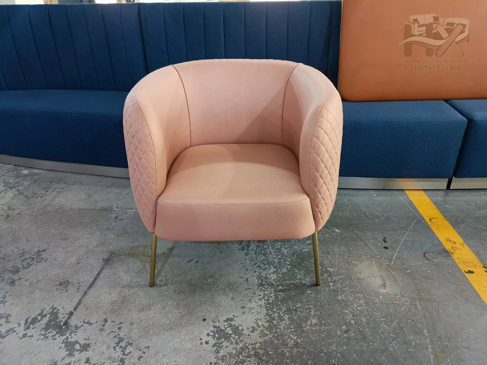 A pink tub chair rounds into short arms while diamond quilting covers the exterior back shell.