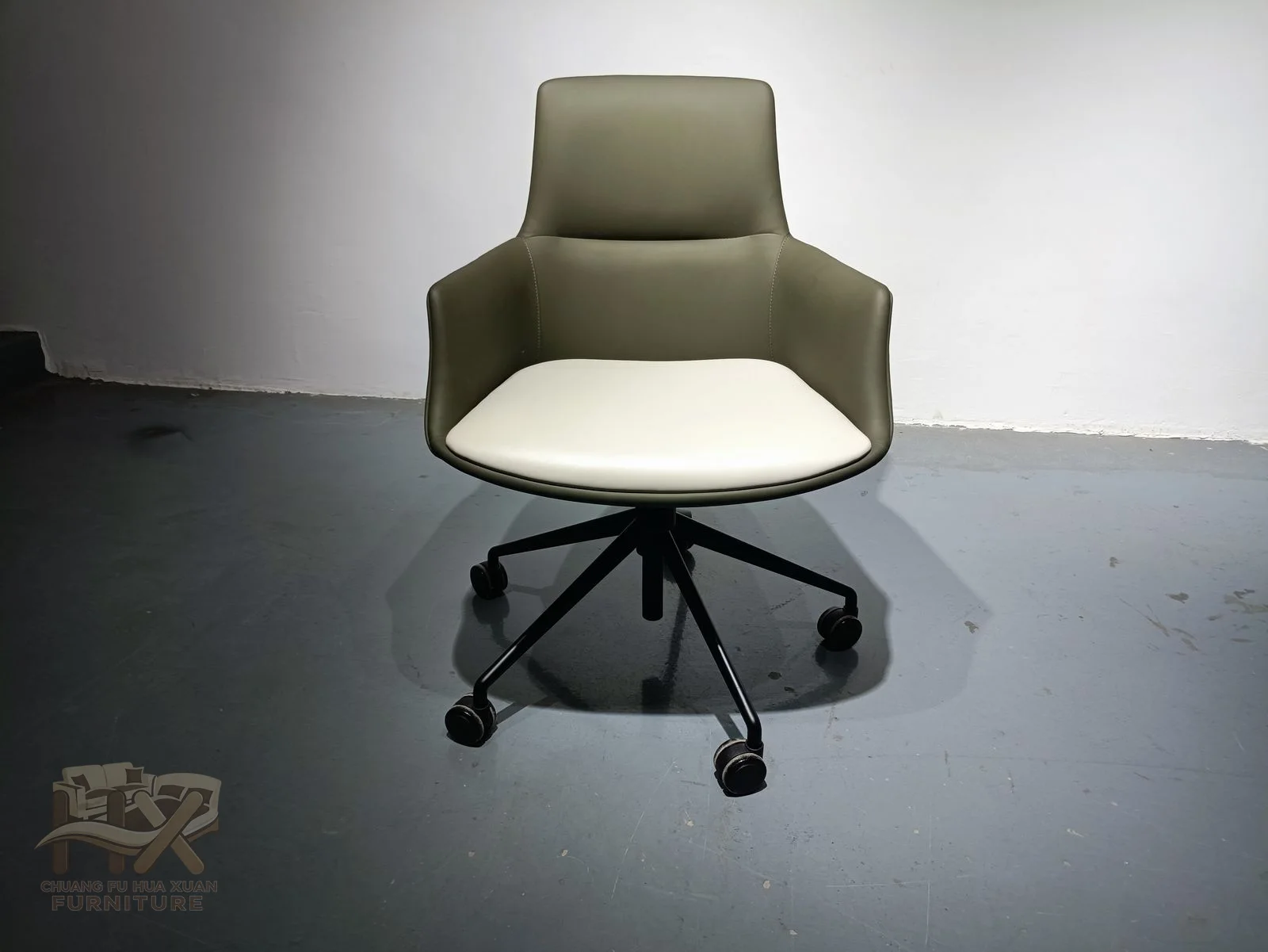 Olive upholstery covers a shaped back and pale seat above a dark wheeled swivel base.