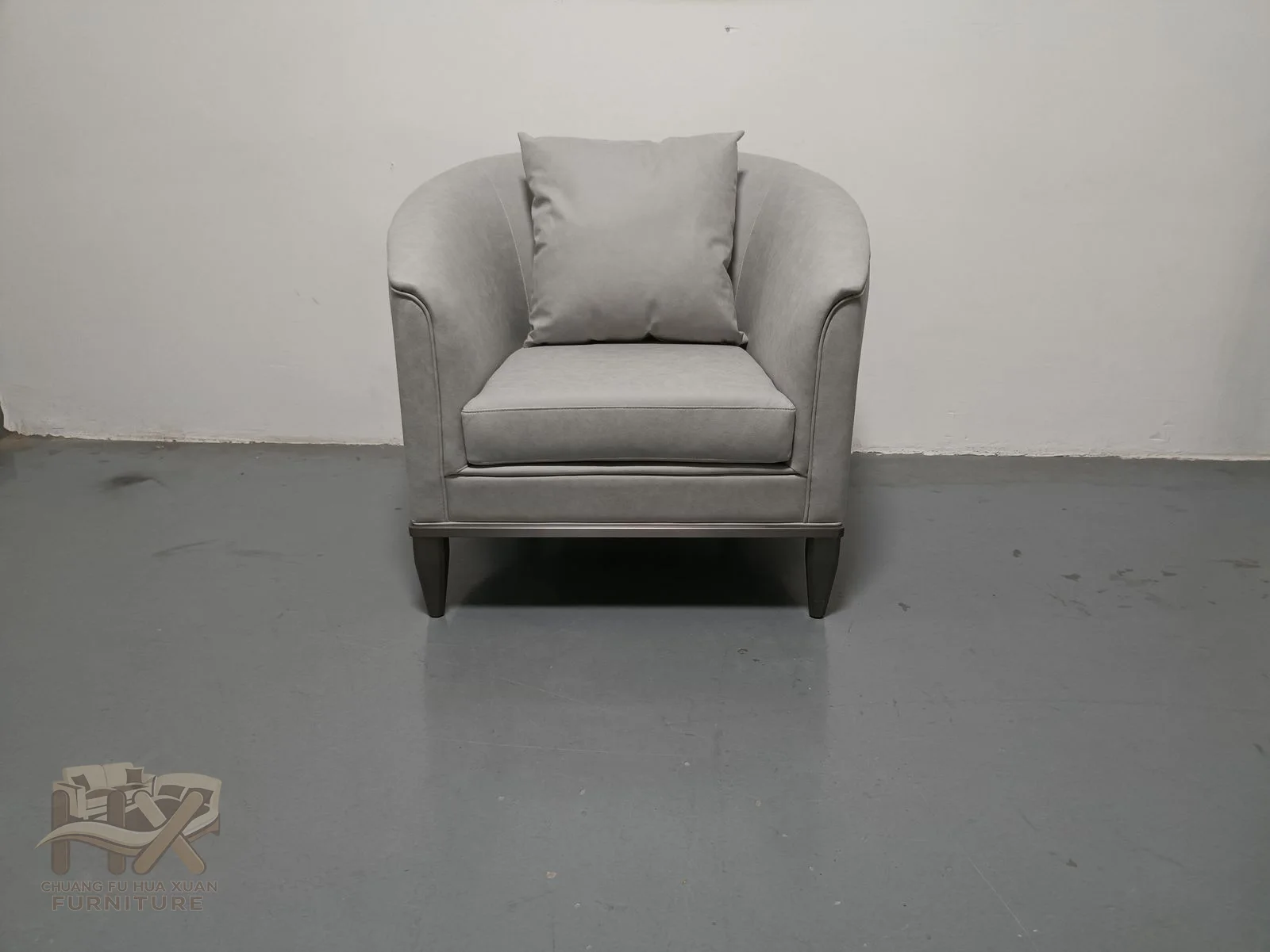 A deep white seat is enclosed by short padded arms and a low back above small dark feet.