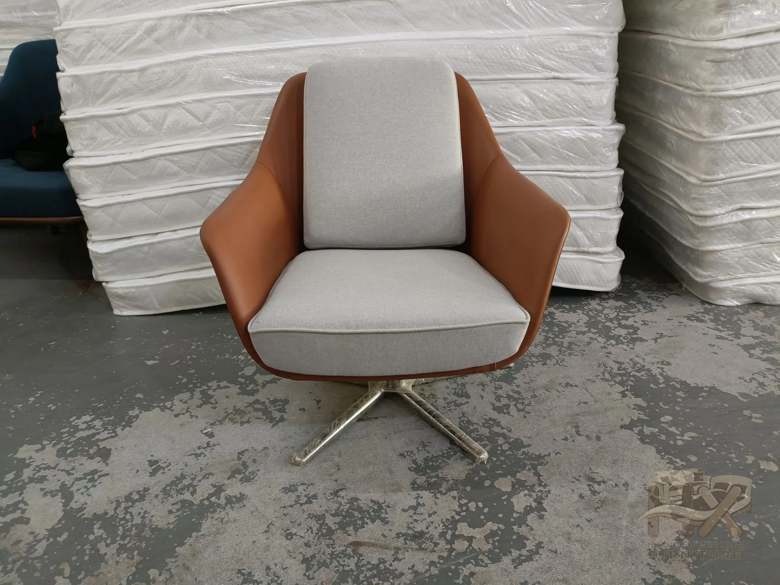 A warm tan seat and back panel curve inside a slim dark frame on angled legs.