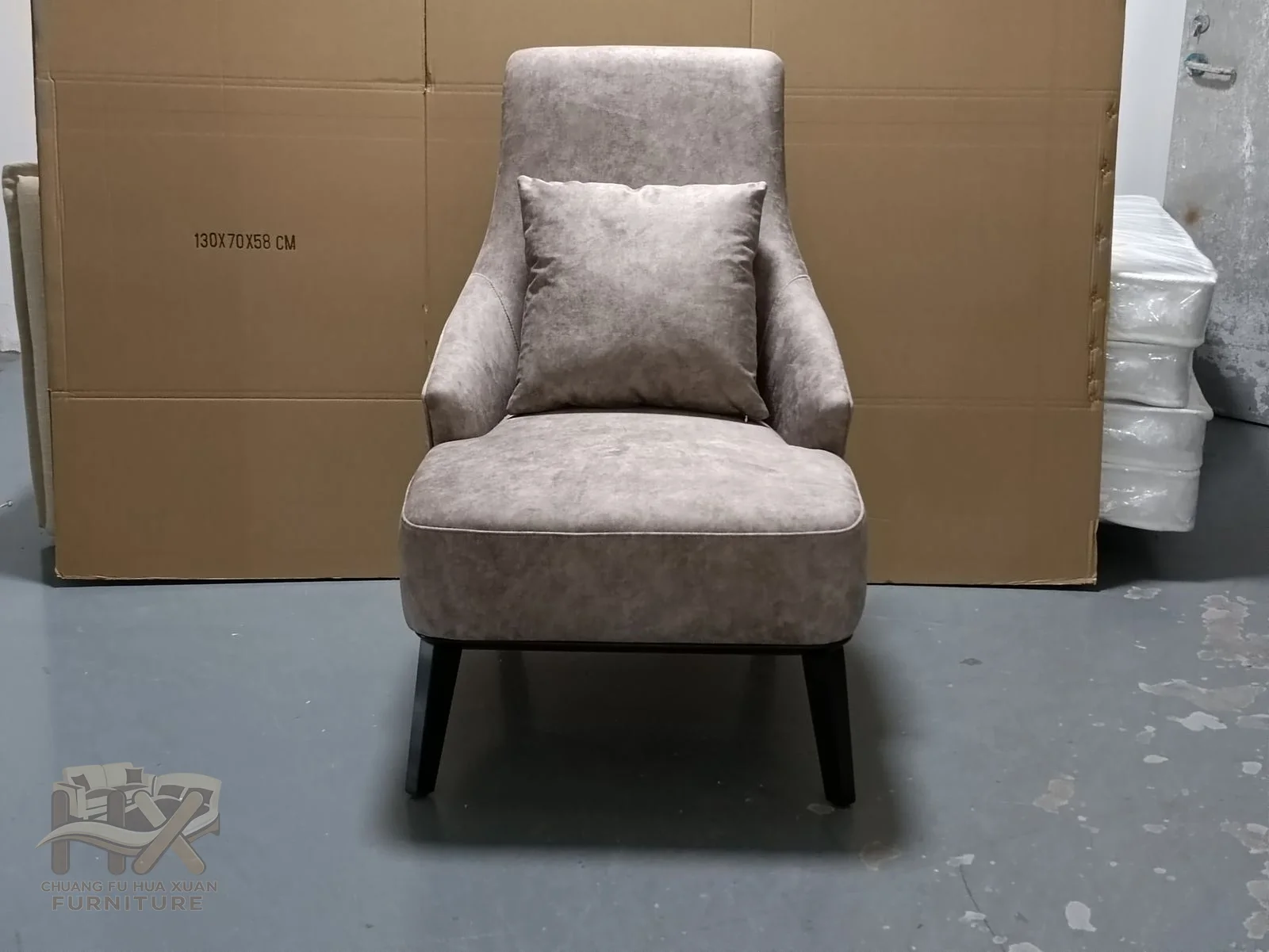 A pale grey high back opens gently at the shoulders above a compact armless seat.