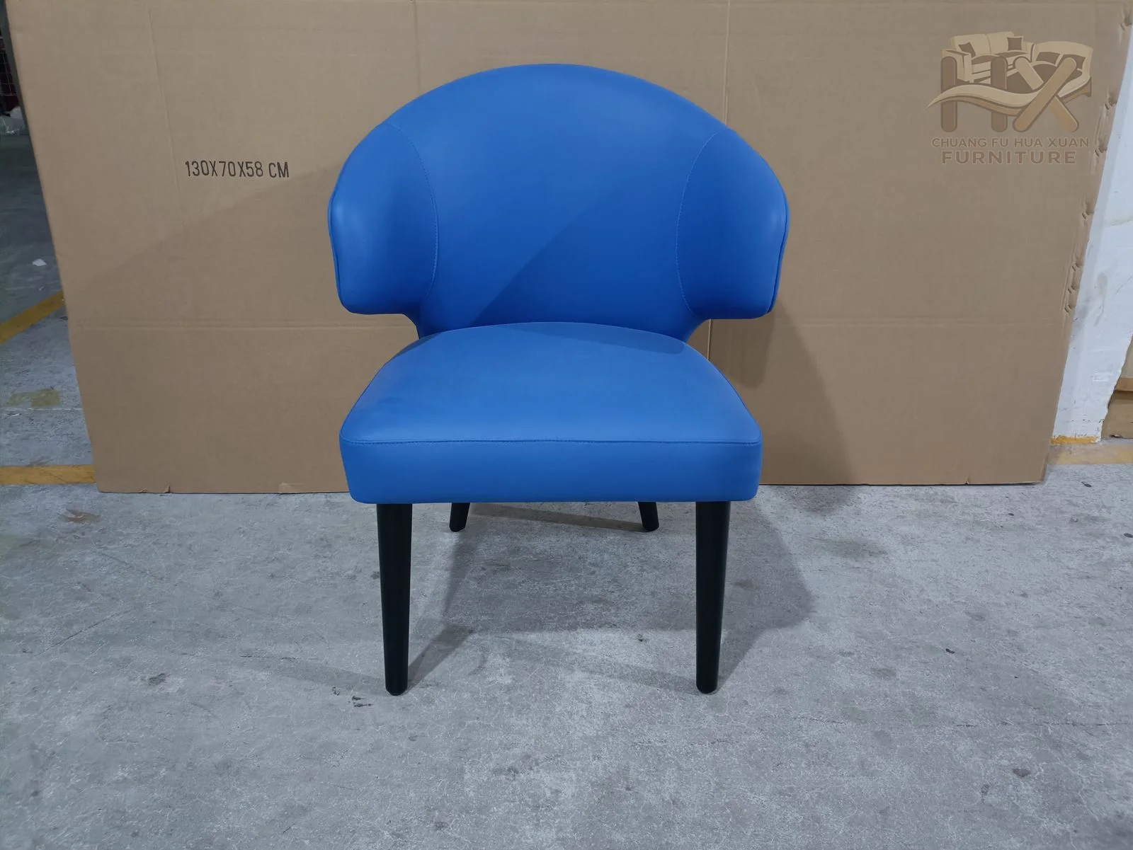 A rounded blue seat carries a separate pillowed head and back form above short concealed feet.