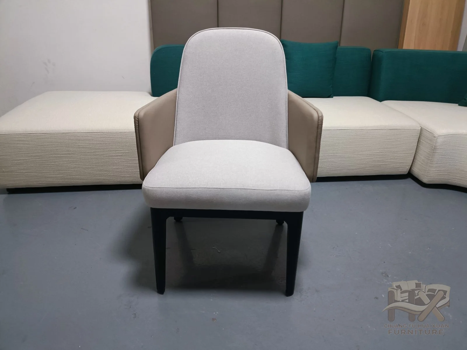A pale individual chair rounds its back and arms into a soft continuous shell.