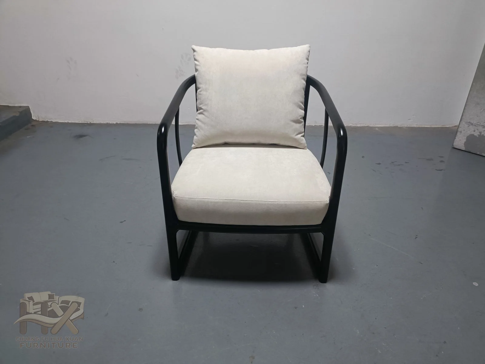 A narrow black exposed frame holds a padded seat and angled upholstered back.