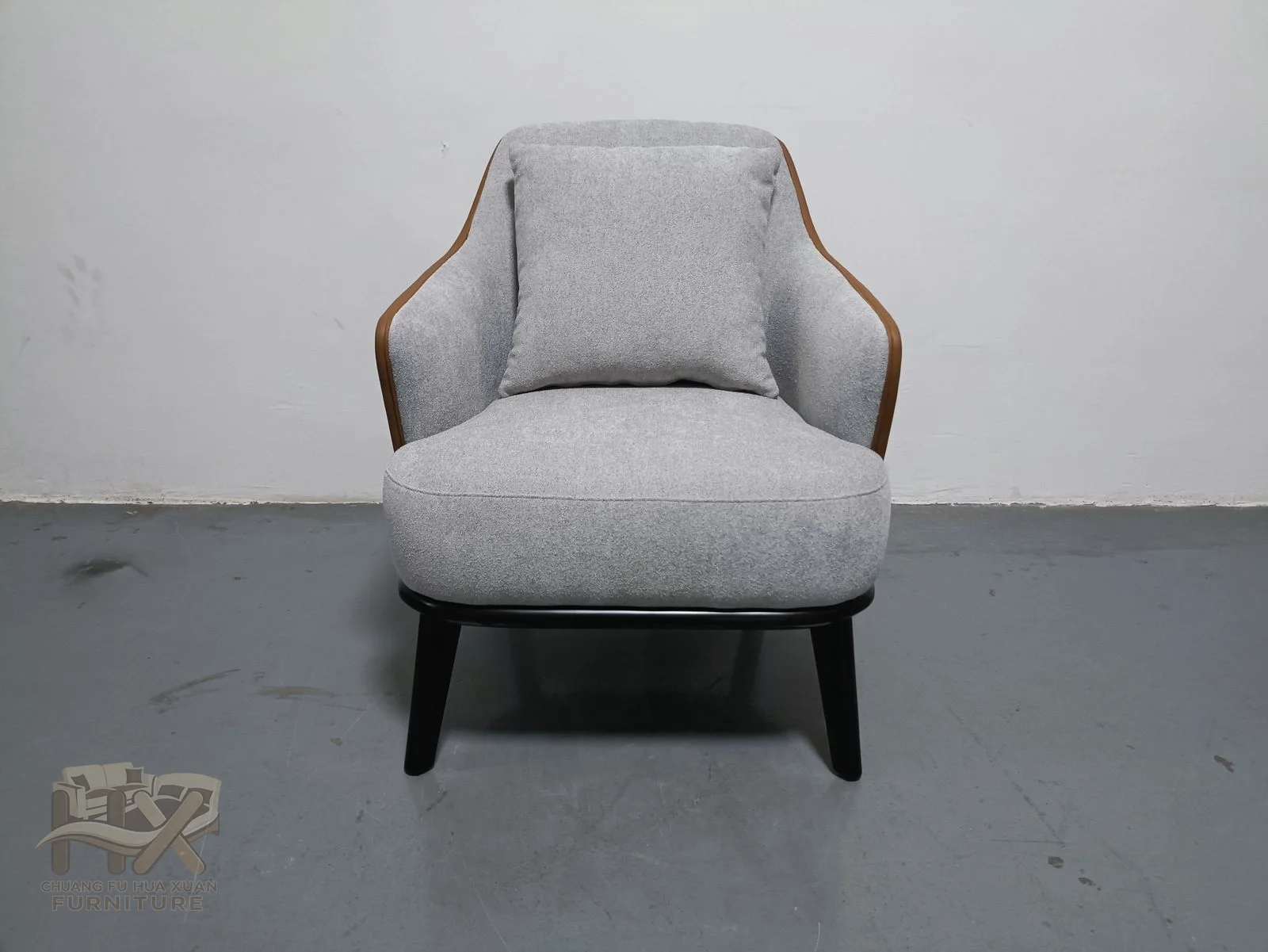 A pale lounge chair has a broad angled back and compact arms around one deep seat.