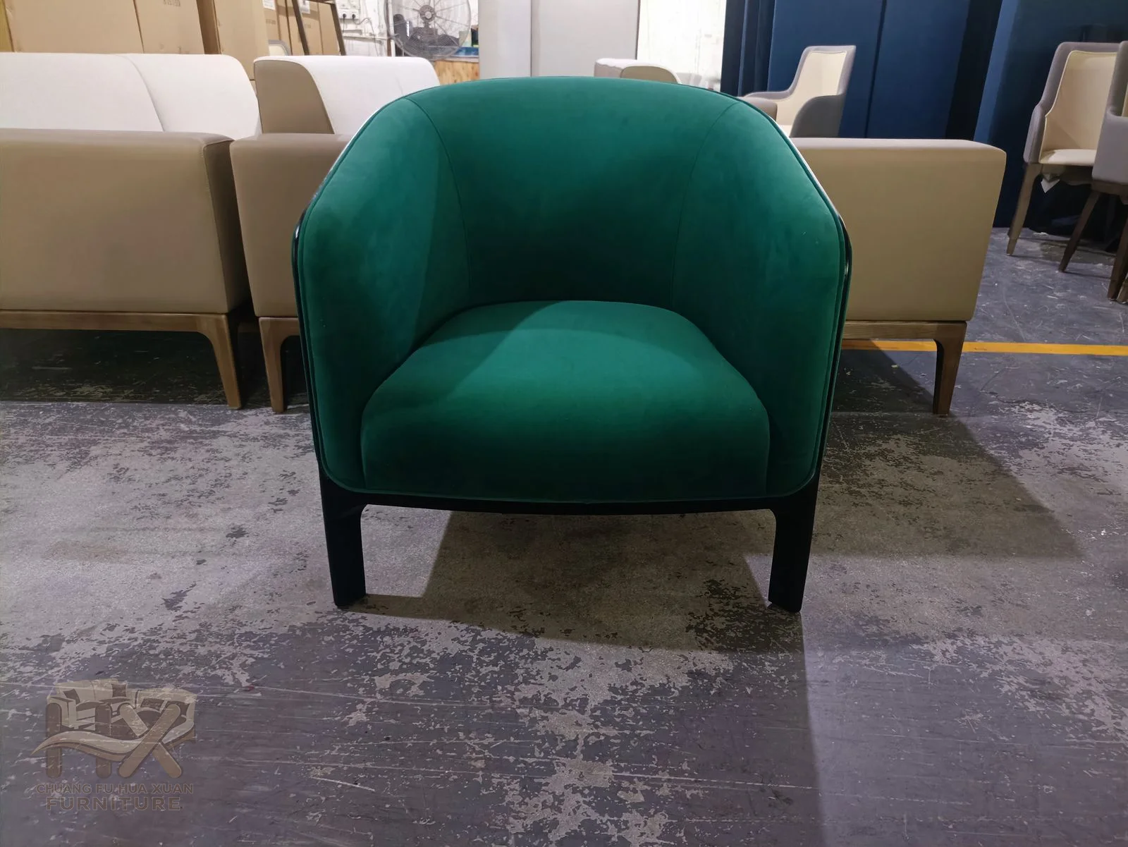 A teal chair has a single rounded seat and a low continuous back and arm shell.