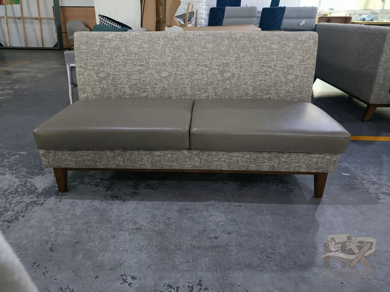 A long grey banquette has a continuous upholstered back and a low straight seat run.