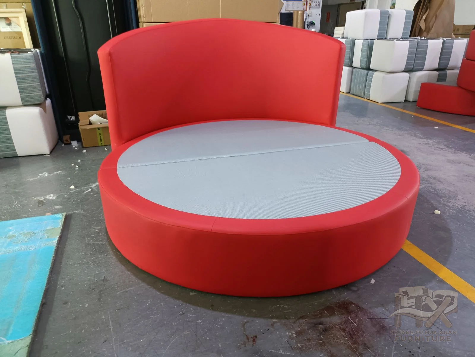 A bright red circular seat sits within a curved partial back around an inset pale cushion.