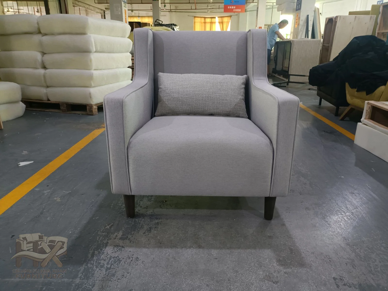 A pale club chair holds one deep cushion within straight arms and a compact back.