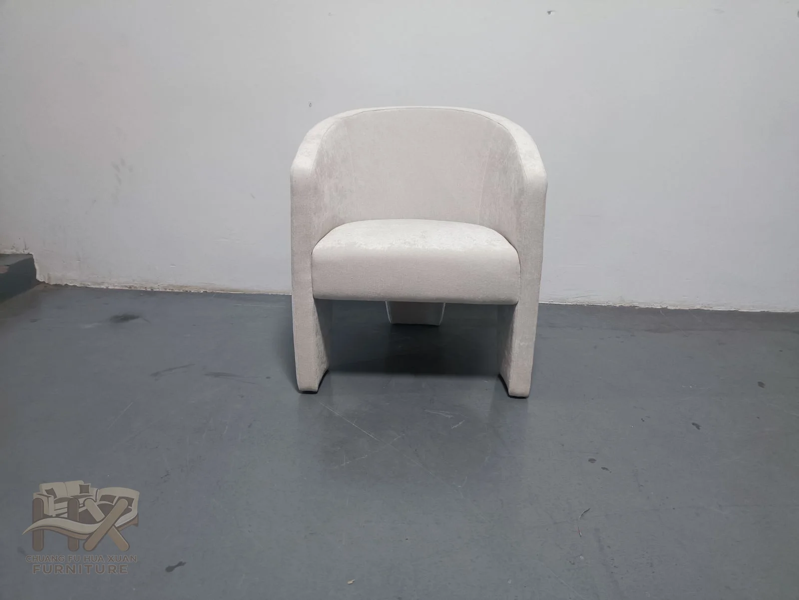 A white chair flares its back and short arms around a small padded seat.