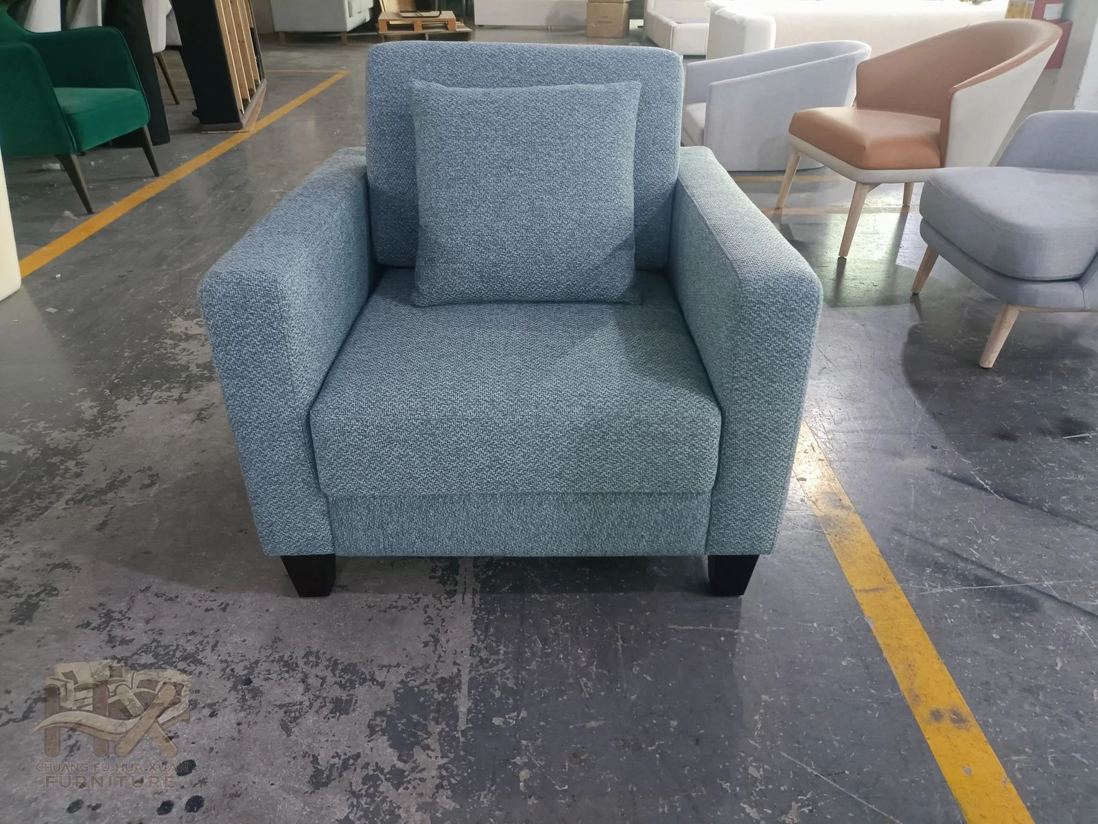 A pale blue chair holds one deep cushion between straight upholstered arms.