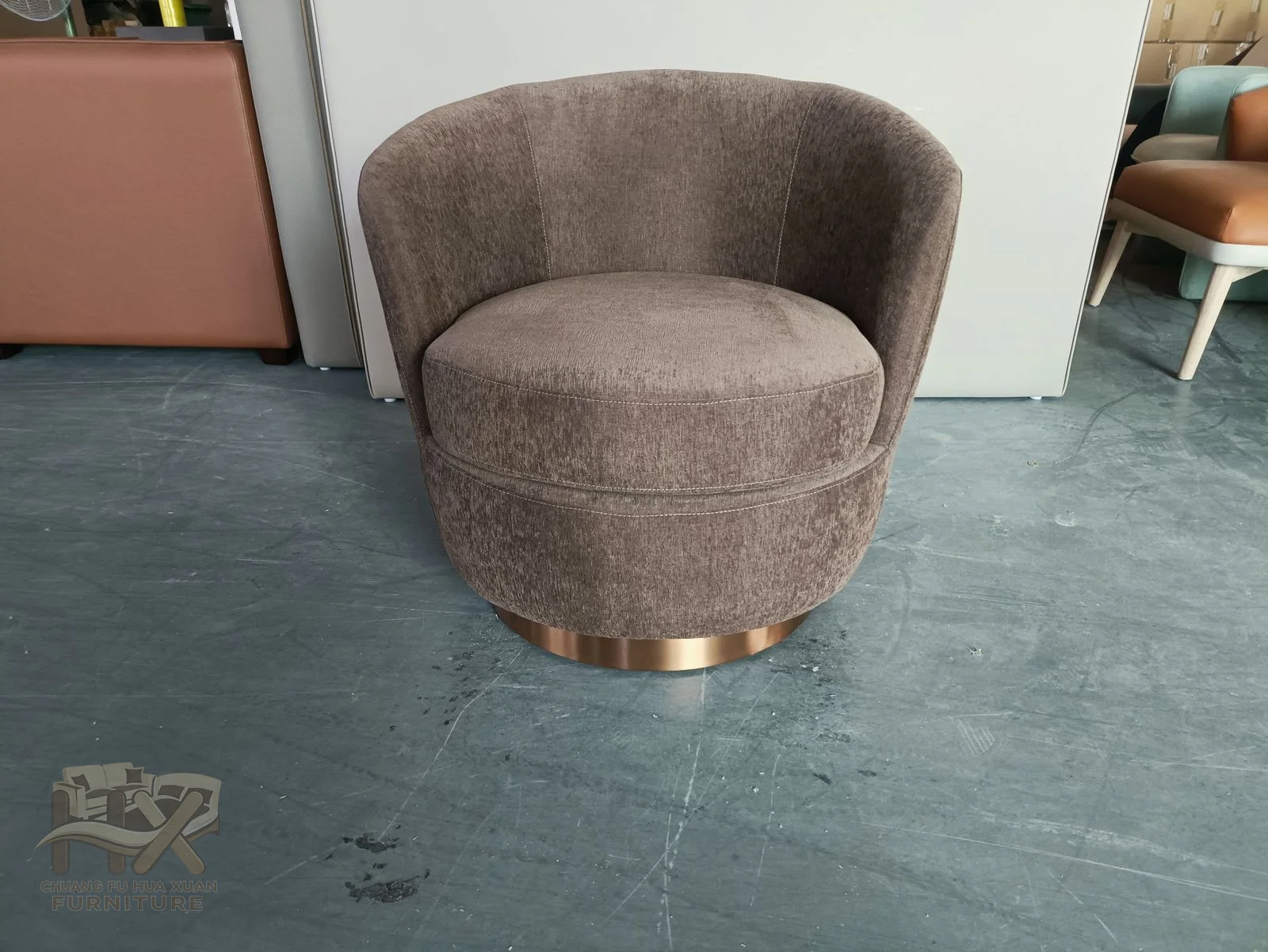 A taupe chair wraps a curved back and arms around a circular individual seat.