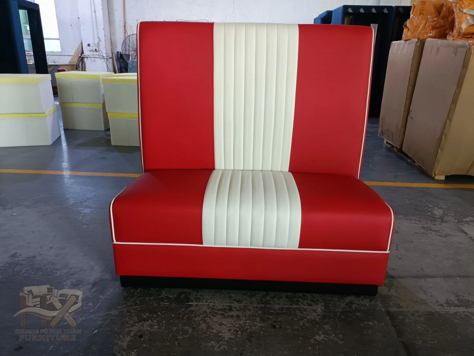 A red banquette has broad white vertical back stripes and a low continuous seat.