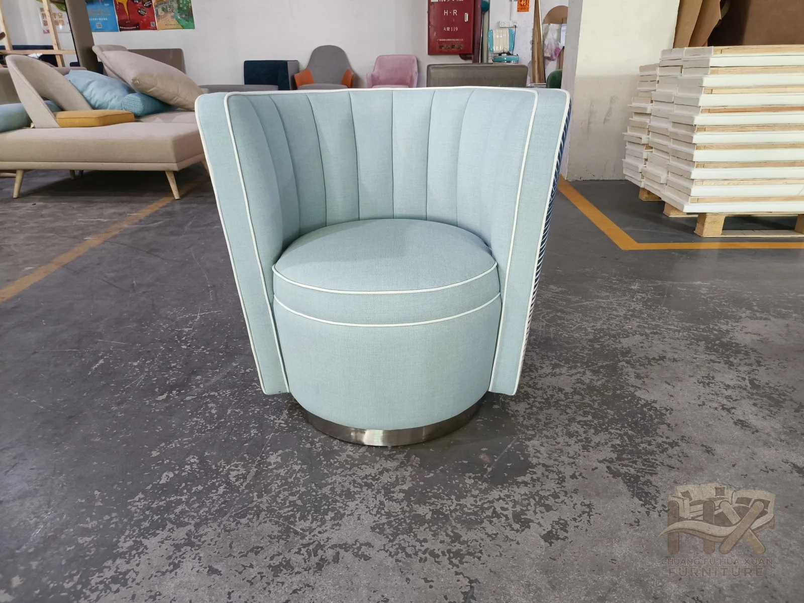 A pale blue tub chair displays vertical ribs across its curved outer back.