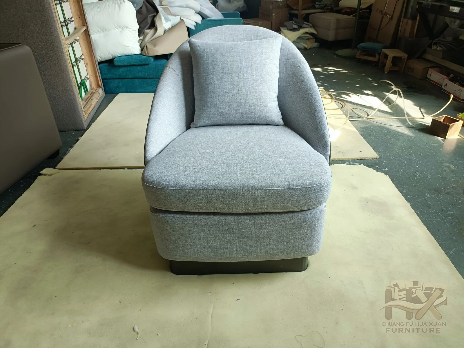 A pale blue lounge chair curves its back and short arms around a broad seat.