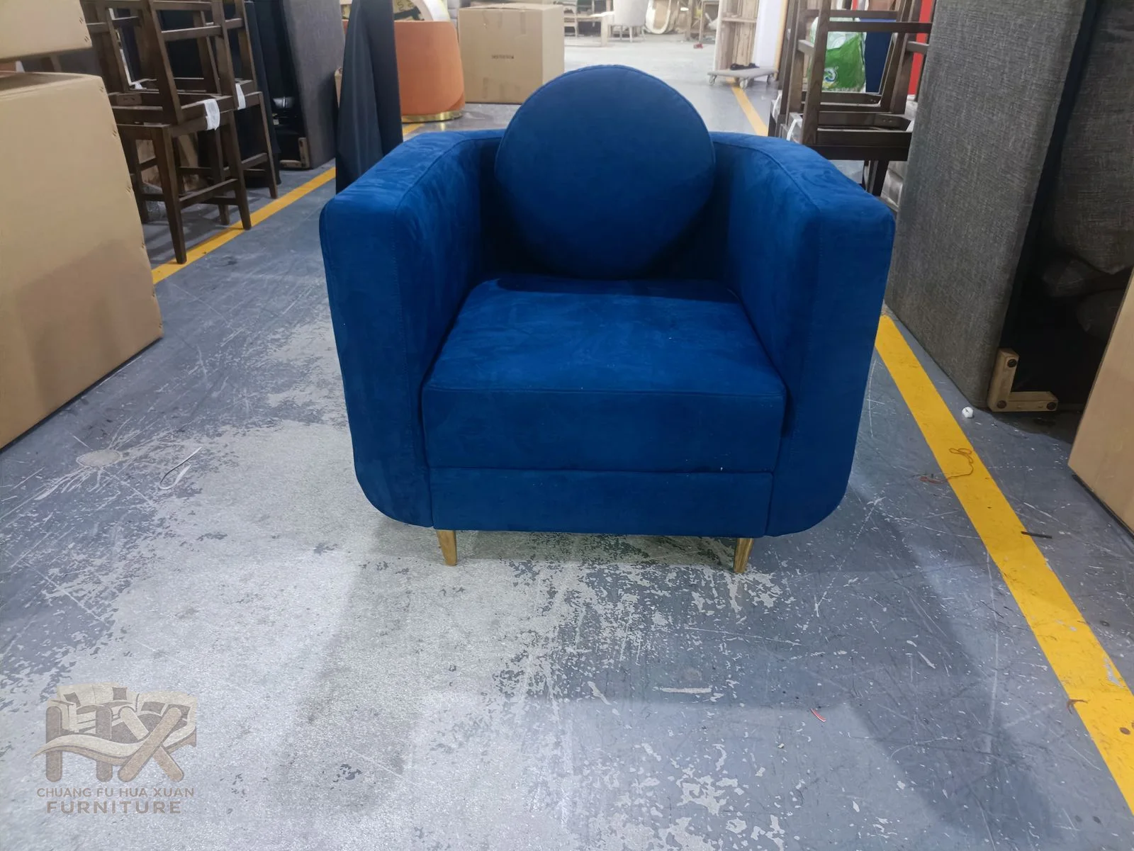 A vivid blue chair wraps straight padded arms around one deep seat.