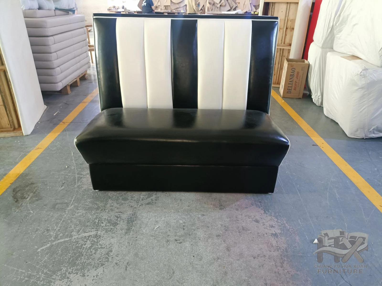 A black banquette carries broad ivory vertical stripes across its upright back.