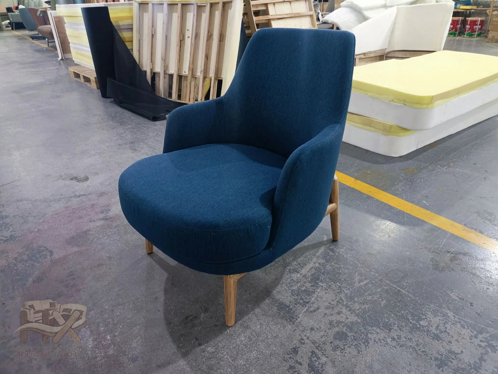A deep blue individual chair combines a rounded seat and upright soft back on a low base.