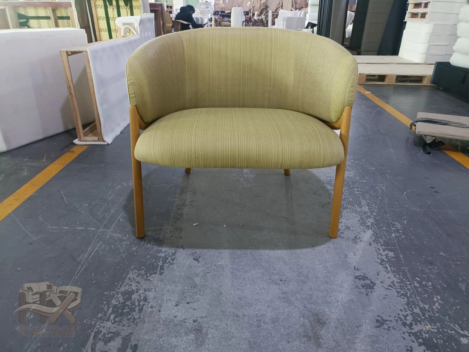 A pale green chair curves its back and short arms around one compact seat.