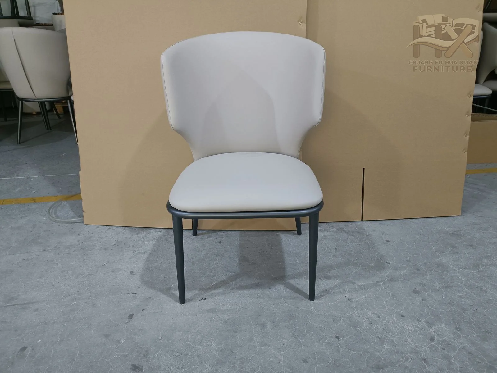 A pale softly shaped back sits above a compact seat on fine dark wire legs.