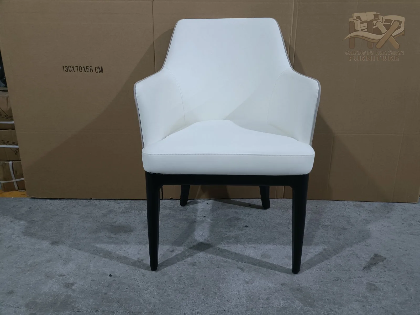 A white faceted back and seat sit on four slim dark legs.