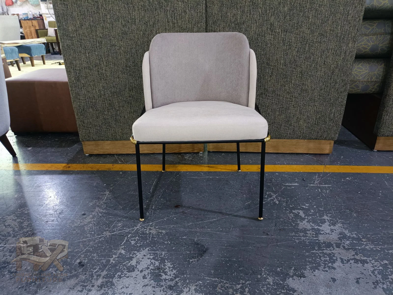 A white padded dining chair has a curved low back on slender dark wire legs.