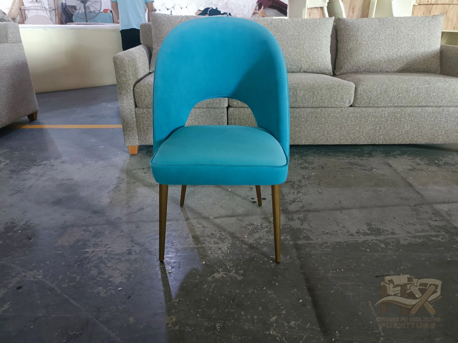 A bright blue padded chair curves around a compact seat on slim metal-look legs.