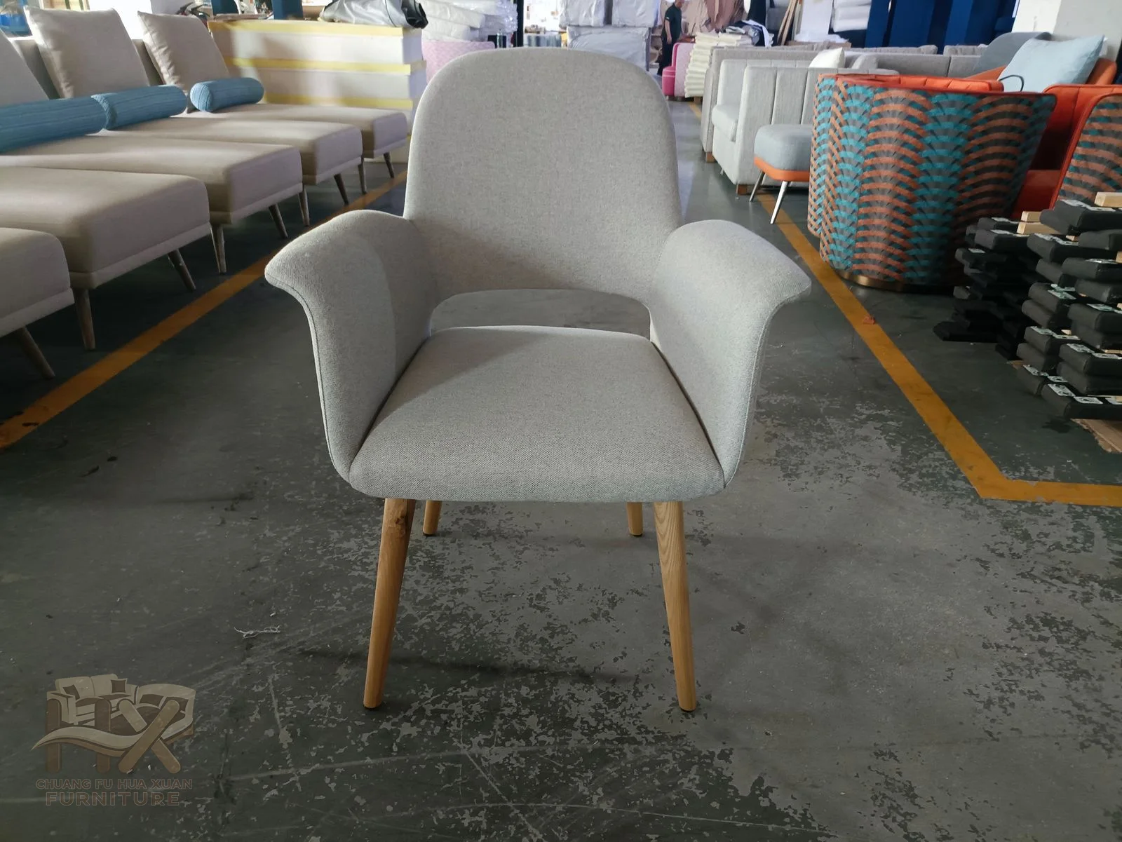 A pale dining chair curves a low back around its seat on four tapered wood-look legs.