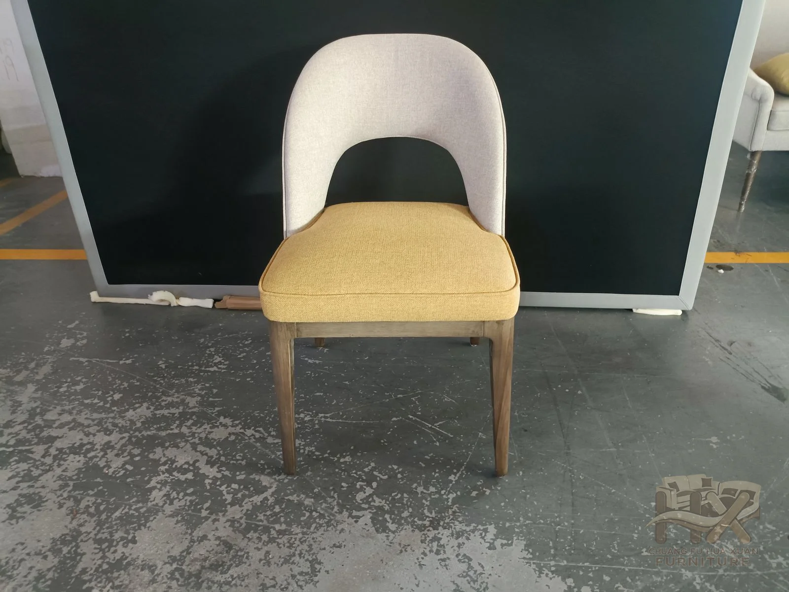 A curved dining chair is shown in cream and mint upholstery above slim legs.