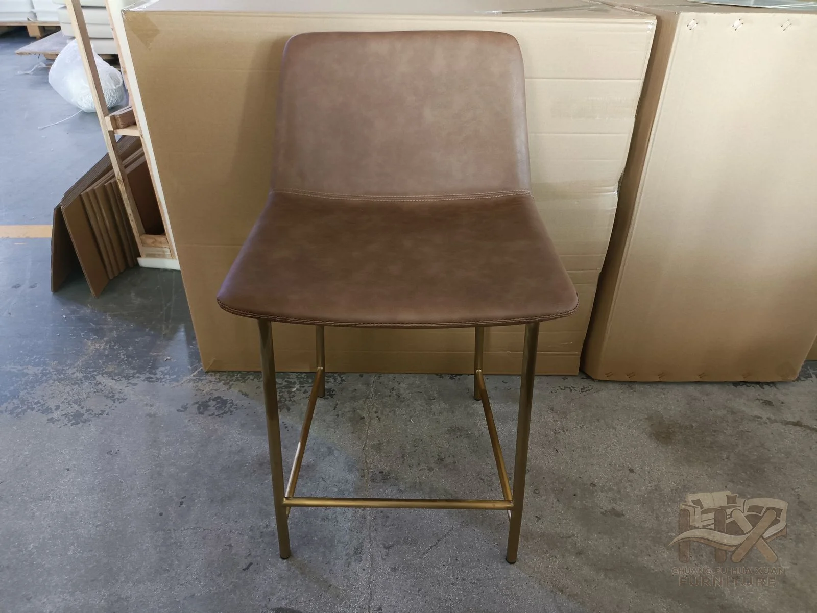 A taupe dining chair has a clean angular back and seat above fine dark legs.