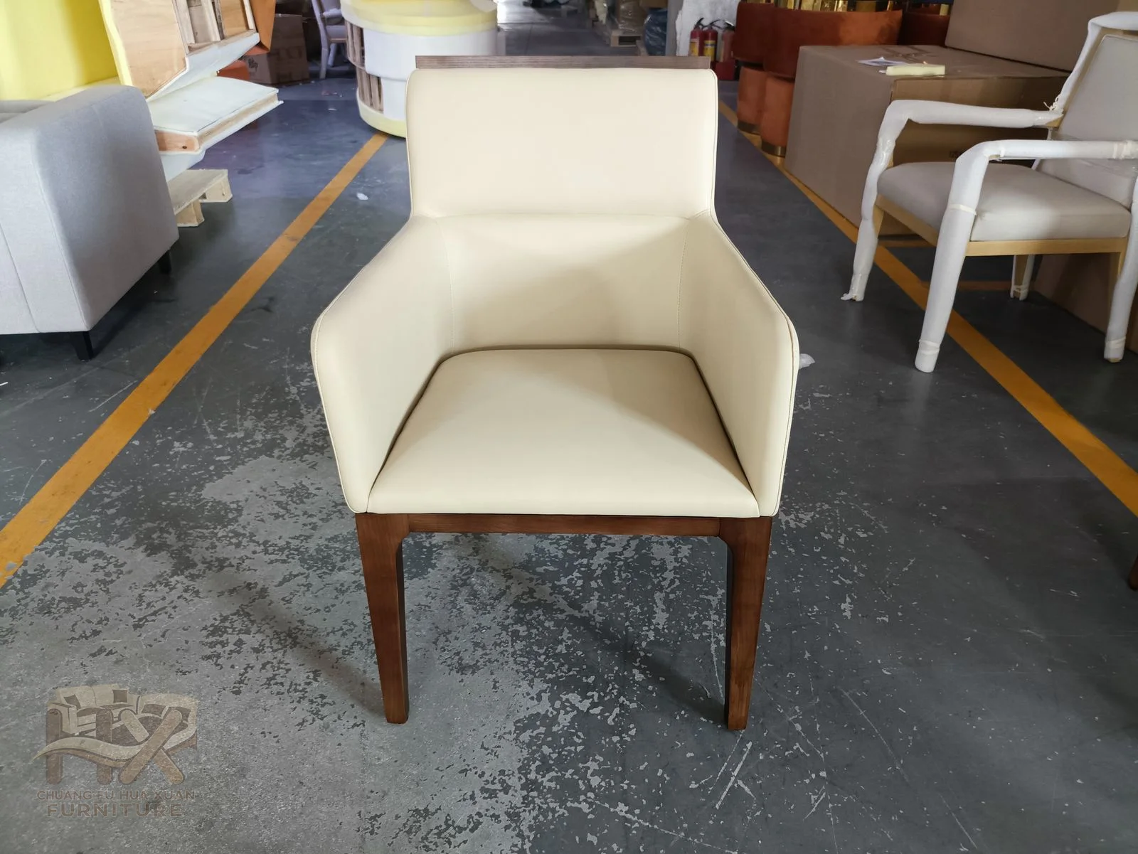 An ivory chair has short upholstered arms and a compact back over tapered wood-look legs.