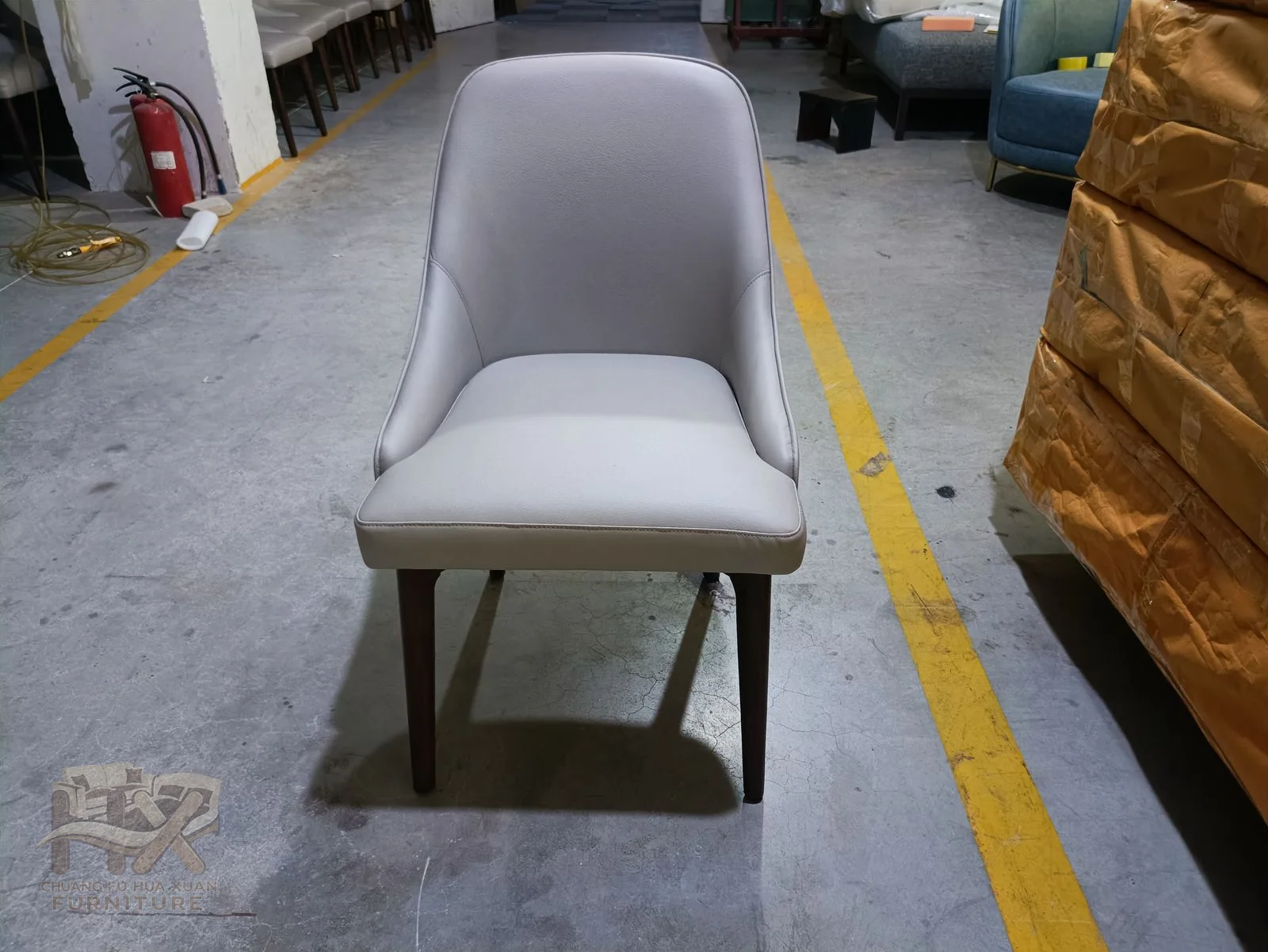 A grey dining chair inclines its padded back above a compact seat on slim legs.