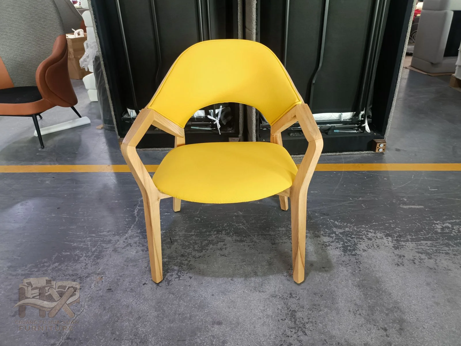 A bright yellow chair has open short arms around a compact padded seat.