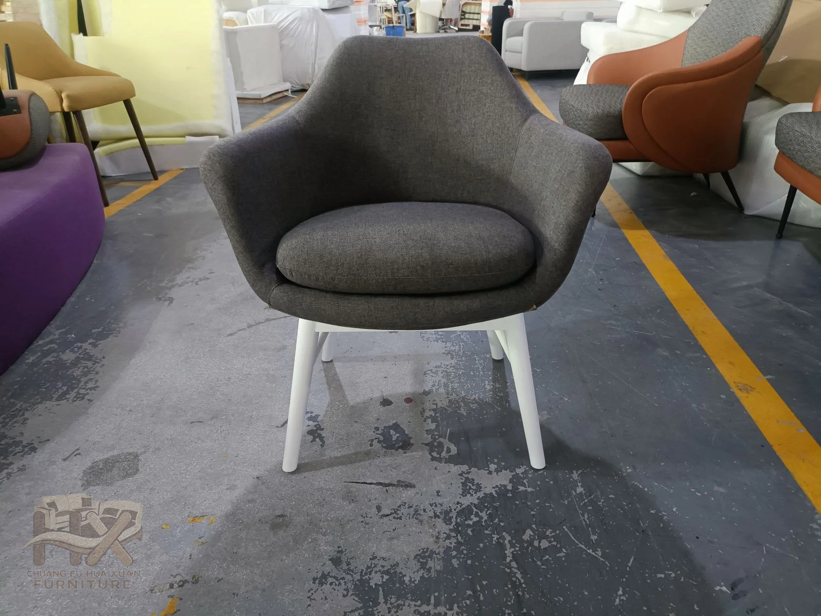 A rounded bucket dining chair is shown in grey and orange on slim pale legs.
