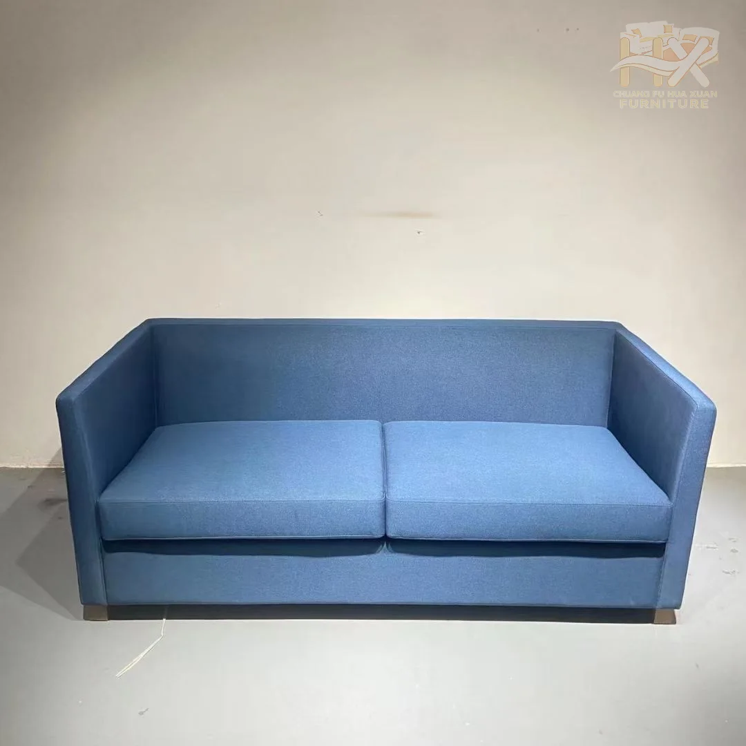 Square blue arms surround a clean two-seat sofa that unfolds into a forward mattress deck.