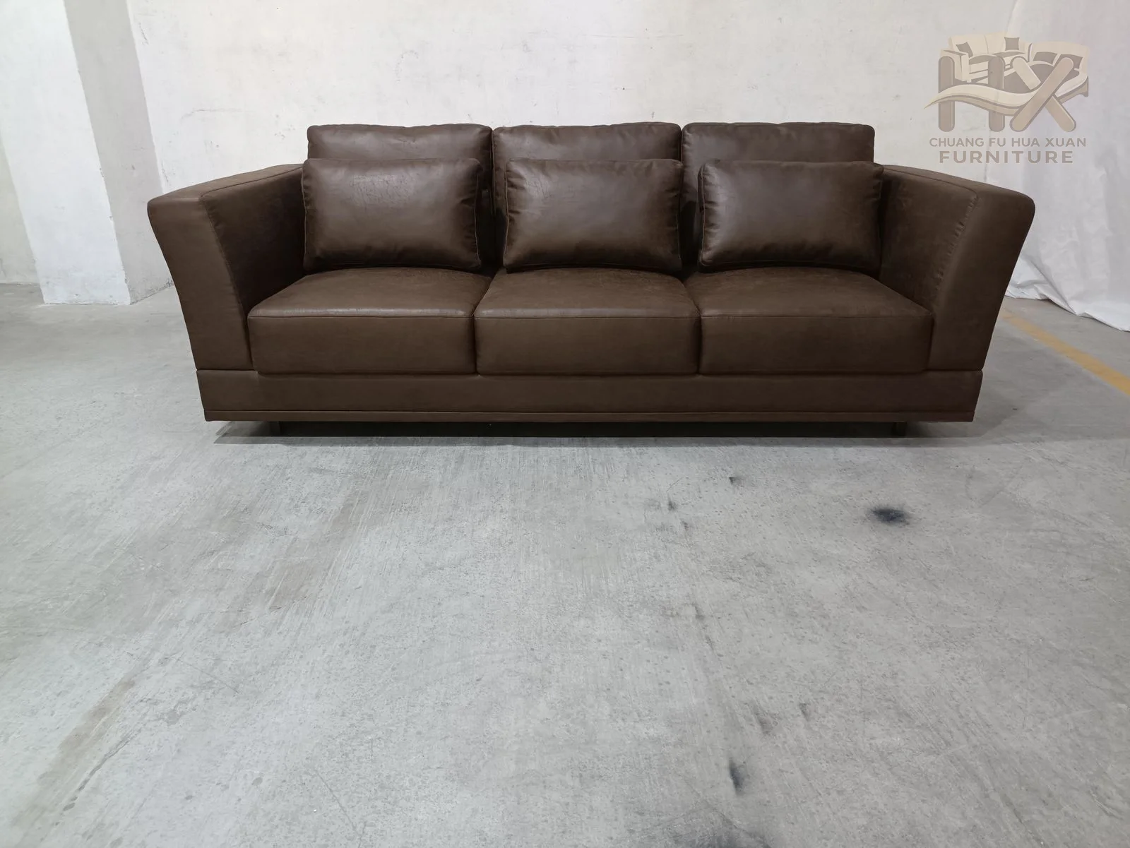 Straight seat cushions and sharply sloped outer arms give the brown sofa and matching armchair a tailored, architectural outline.