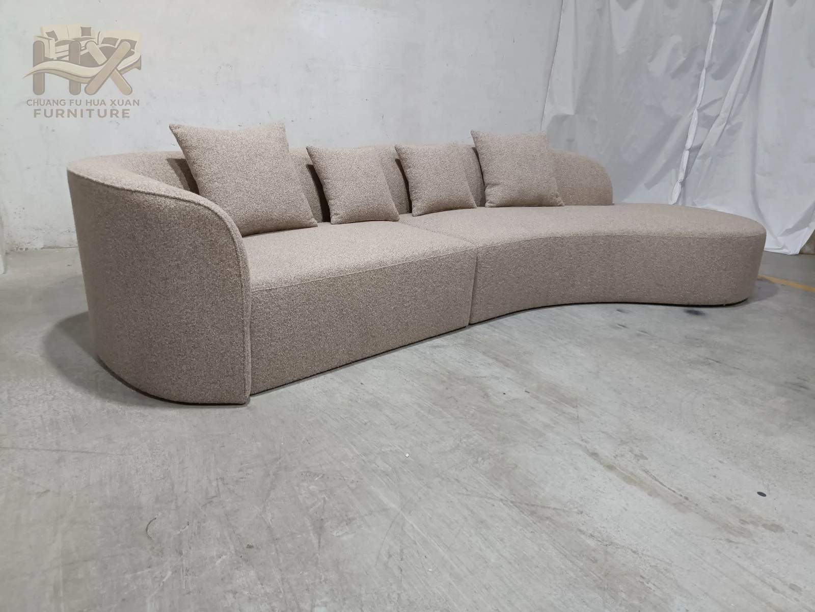 The seat runs through an extended S-shaped curve, with a low back and loose cushions following the changing radius.