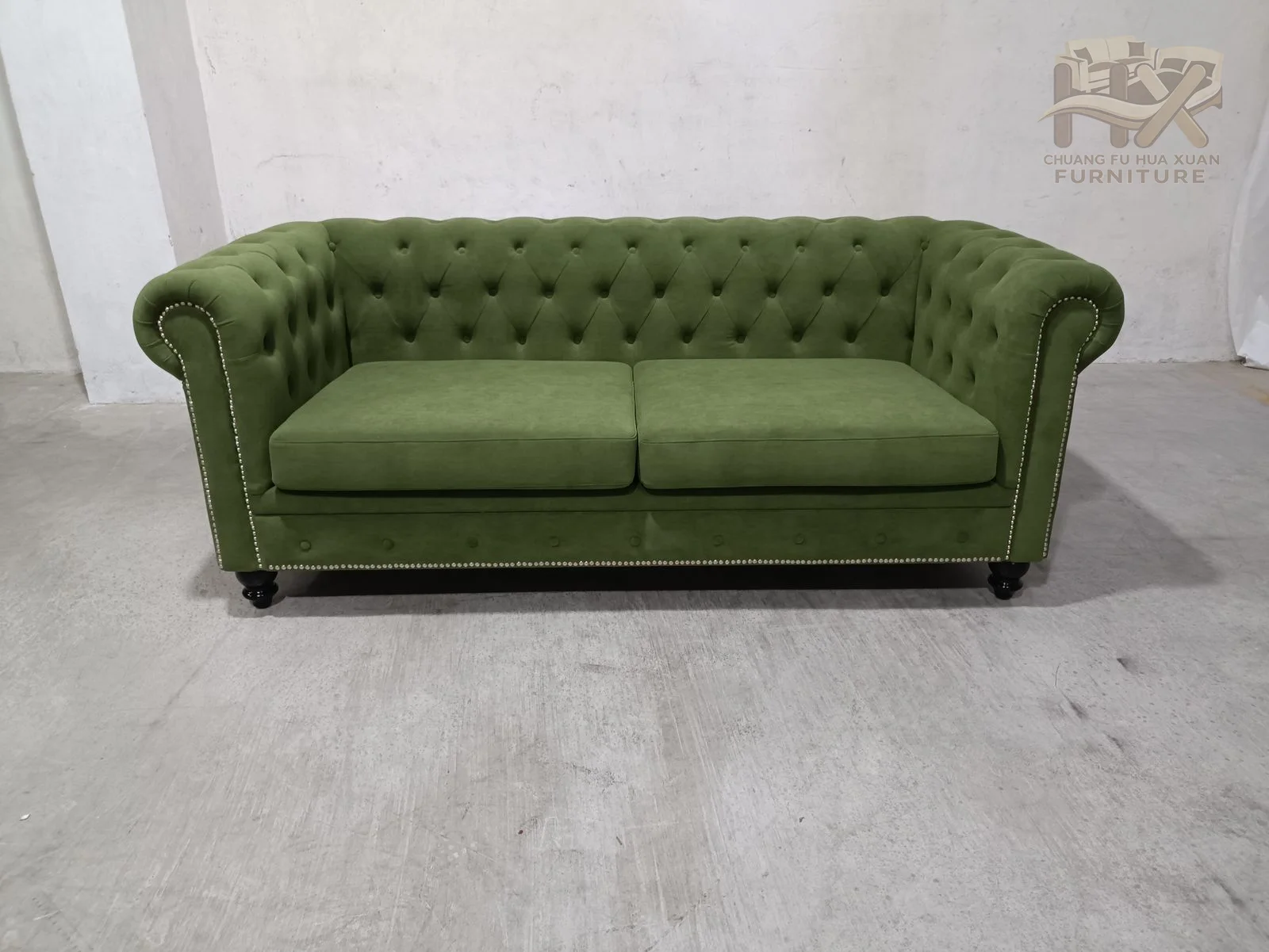 Deep buttoning covers the back and inside arms, while substantial rolled arms and a low seat rail give the green sofa a traditional profile.