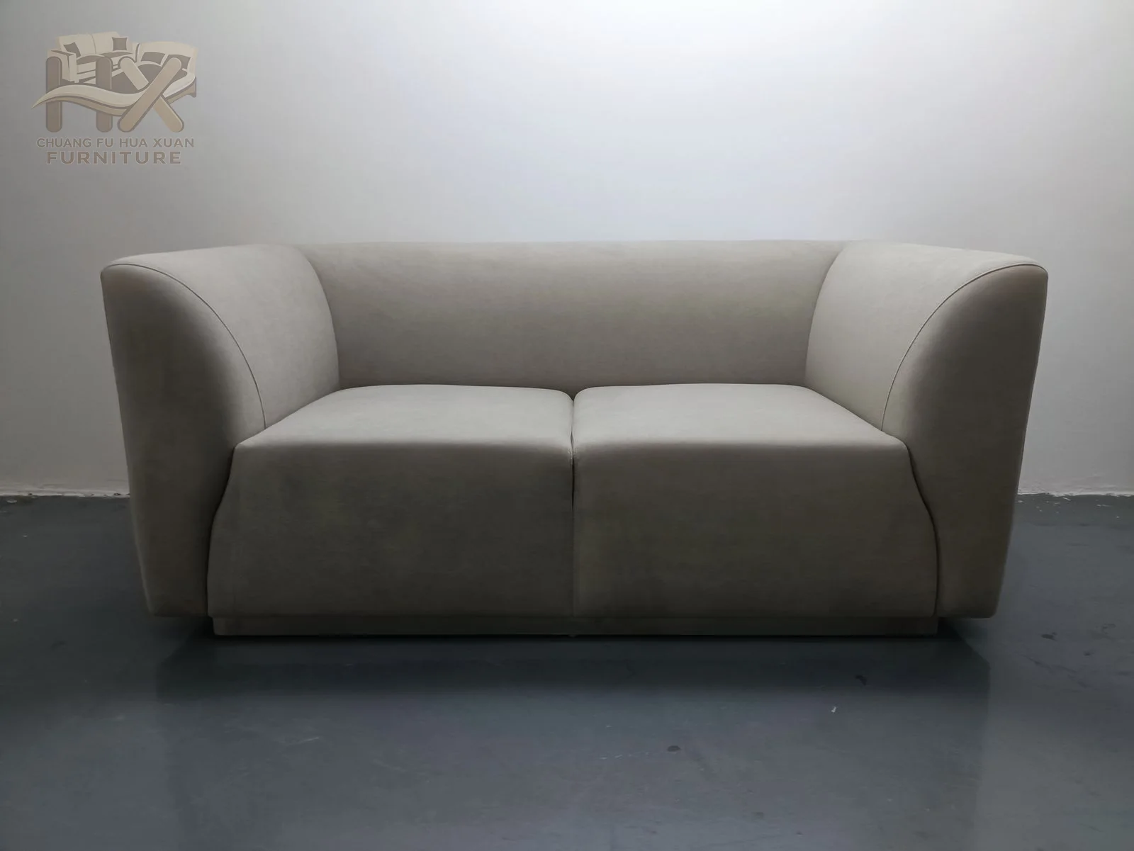 A grey two-seat sofa narrows toward the floor as its arms slope outward above a straight upholstered base.