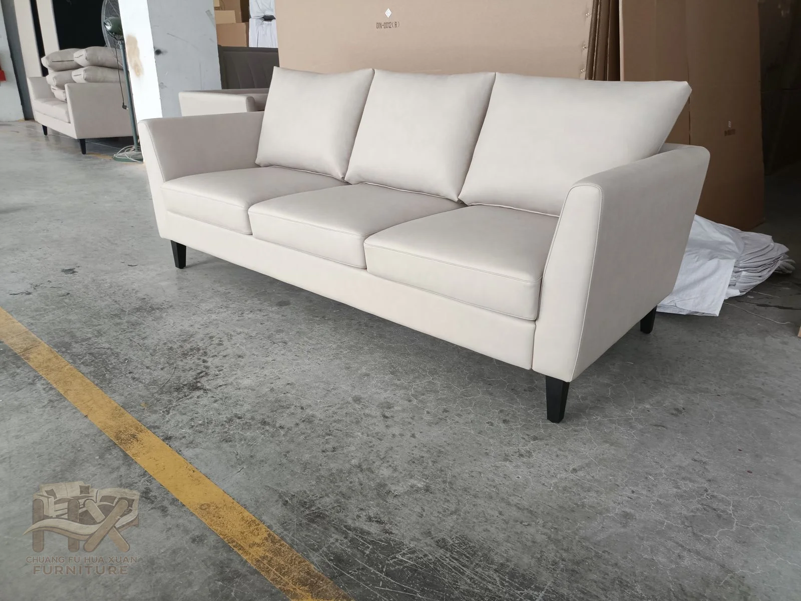 A long white seat is held between square arms, with three separate soft back cushions above the low frame.
