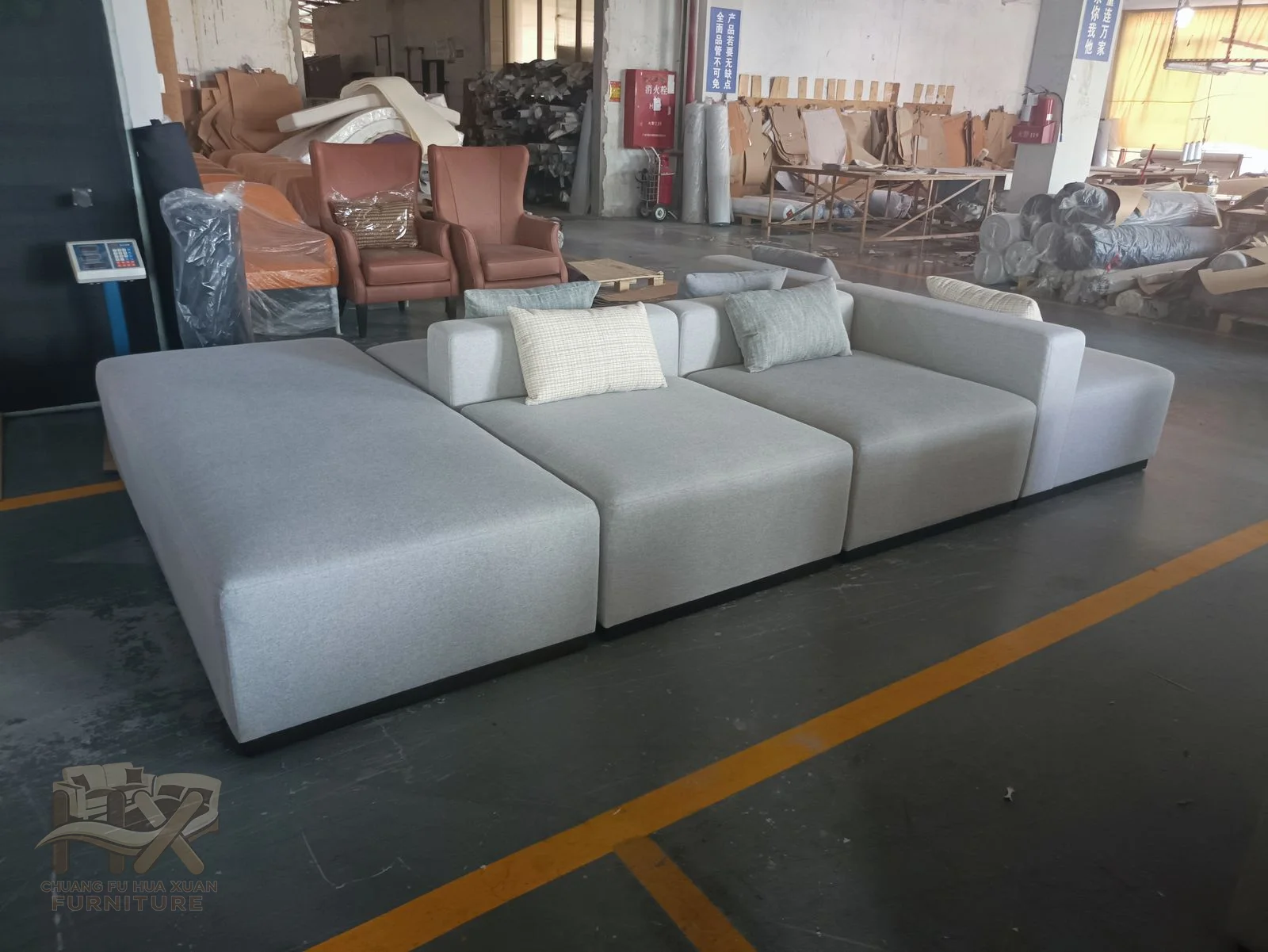 Several low grey modules form a wide corner arrangement with deep seats and separate back cushions.