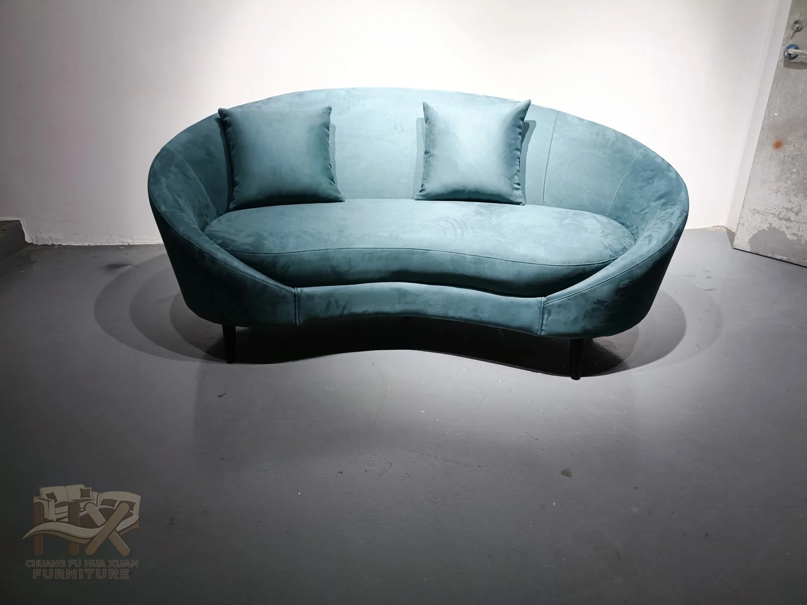 A continuous oval blue shell encloses a sweeping seat and several narrow back cushions.